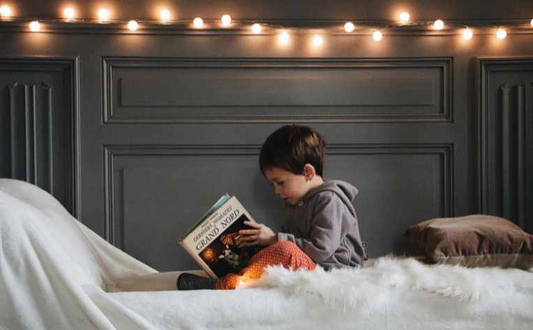 hygge lights and sherpa rug on bed where boy is reading